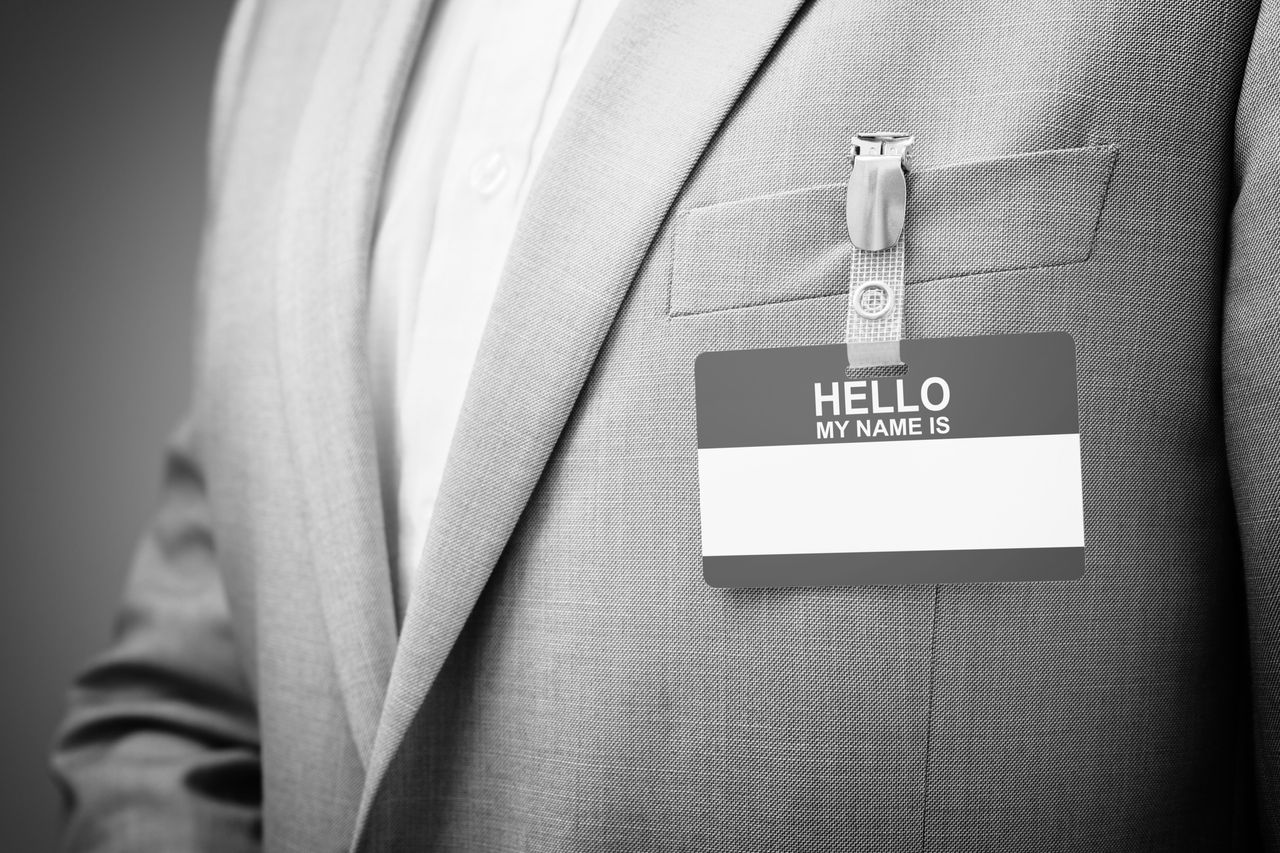 Businessman wearing Hello my name is tag Businessman at an exhibition or conference wearing a Hello my name is security identity name card or tag